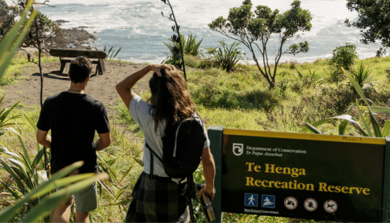 Two people walking in Te Henga Bethells Beach in Auckland